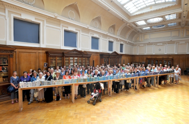 A long line of blue-spined books selected by GWL users, displayed on a long narrow table at the Mitchell Library