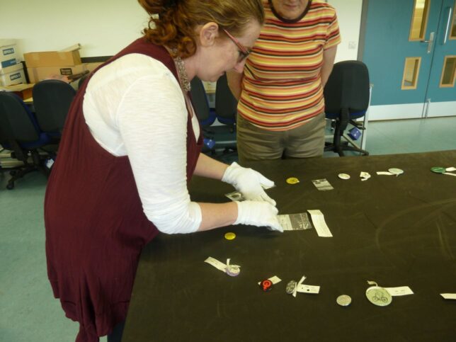 Fiona Hayes, Social History Curator, with the badges from GMRC's collection. 