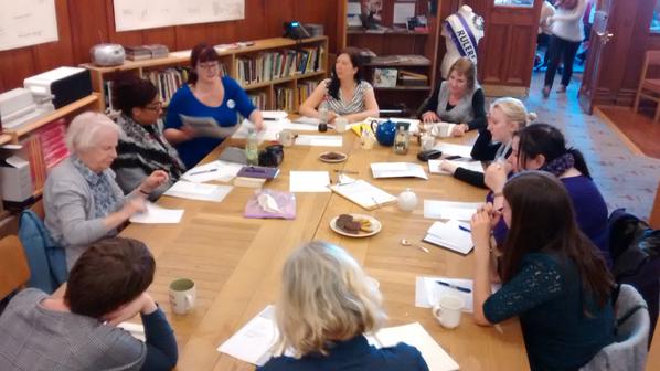 Women around a table in GWL participating in a writing workshop