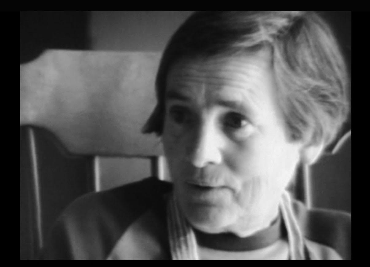 Still of video interview in black and white. Close up of Agnes Martin's profile as she speaks to someone off camera.