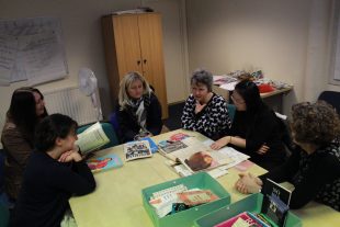 A group of women looking at the mini archive of GWL in Dundee