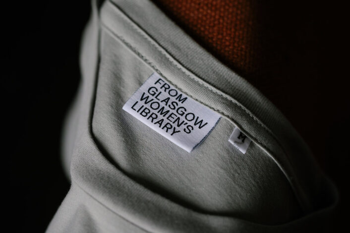 Close up of the labels on the 'From Glasgow Women's Library' t-shirts. The text says 'From Glasgow Women's Library'.