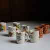Slogan Mugs all displayed on a table