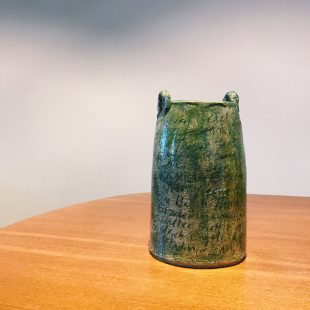 Photograph of one of Fiona Jack's ceramic pieces installed in the Our Red Aunt exhibition at GWL in 2018. The ceramic piece has a green and brown glaze and has names of authors inscribed into the surface. They aren't fully legible in the photograph but they inspired this blog post.