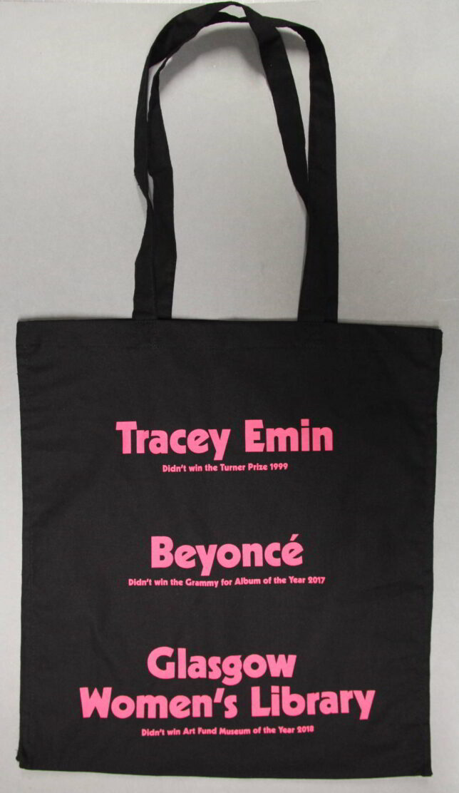 Black bag with bright pink text. The text reads 'Tracey Emin' [in large letters] 'Didn't win the Turner Prize 1999' [In smaller writing]. The rest of the text echoes this style of a larger name and smaller text. 'Beyonce didn't win the Grammy for album of the year 2017' and 'Glasgow Women's Library didn't win Art Fund Museum of the Year 2018'