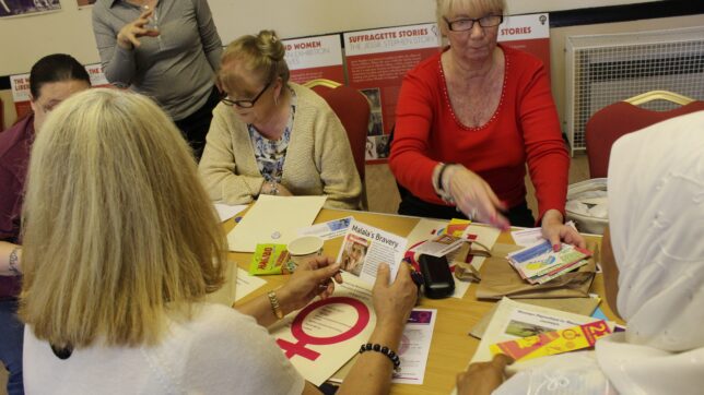 Workshop attendees sort cards with events from the struggle for women's equality