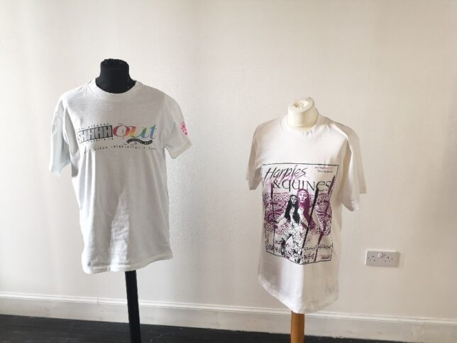 Two t-shirts displayed side by side. The t-shirt on the left says "Shhhh Out" and the right-hand t-shirt shows the cover of an edition of Harpies and Quines.