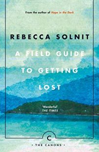 Cover of A Field Guide to Getting Lost by Rebecca Solnit (A series of blue hills looking hazy and merging with the clouds. The authors name is at the top in black and the title is in white capital letters.)
