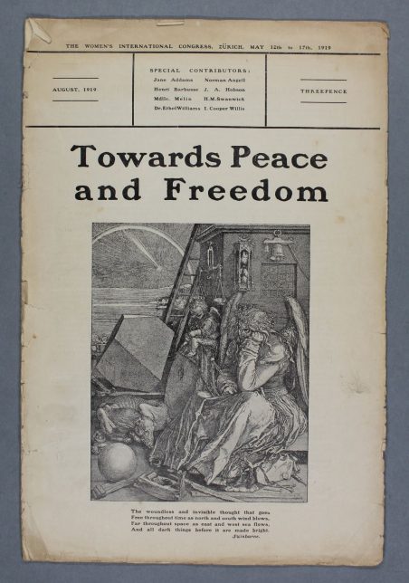 An old booklet that is slightly browned with age. 'Towards Peace and Freedom' is written in bold lettering above a black and white illustration depicting an angel who looks fed up, surrounded by different objects.