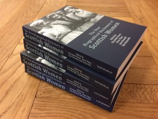 Stack of four New Biographical Dictionary of Scottish Women books on a wooden table.