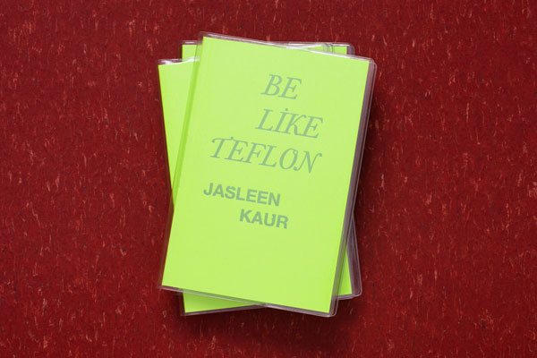 A stack of Jasleen Kau's book Be Like Teflon on a red surface. The book has a bright green cover with the text in capital letters in a silver font.