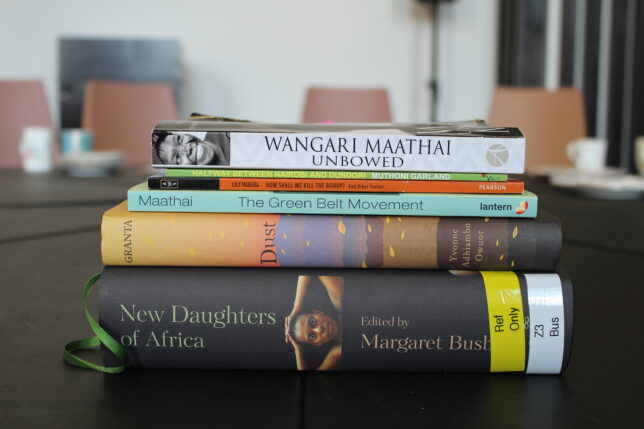 Close up of a stack of six books of fictional writing by Kenyan women writers.
