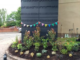 Planted area around GWL's lift tower which has bunting on it.