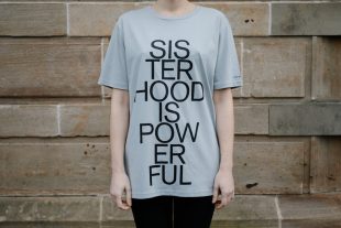 Photo of a grey t-shirt with the words Sisterhood is Powerful' on the front.