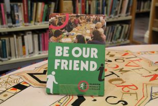 A display of GWL Friends leaflets with the title 'Be Our Friend' stands on a colourful table with bookshelves behind.