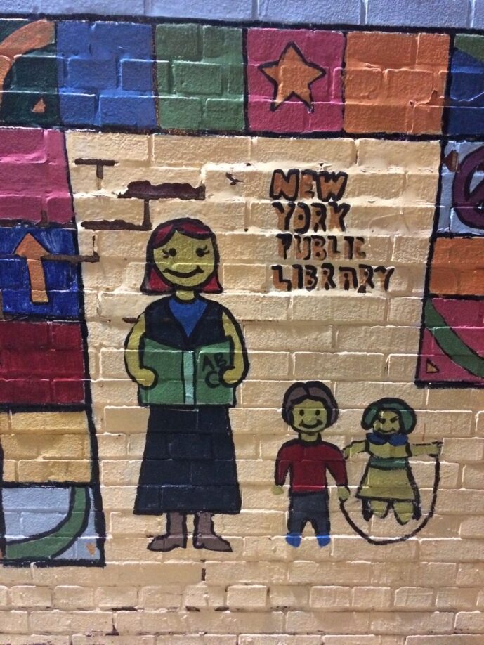 Colourful street art work entitled New York Public Library, seen near New York Public Library. The woman holds an open book; one of the children has a skipping rope; all of them are smiling.
