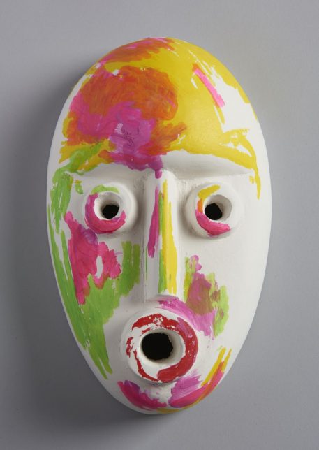 Mask (Yellow), 2018, by Ruth Barker - a stylised white ceramic mask painted abstractly with shades of yellow, pink and green