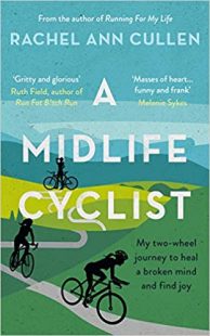 Cover of a Midlife Cyclist. The cover image is a drawing of fresh, green hills and a nice blue sky. There is a long pathway winding through the hills and there are silhouettes of three cyclists at different parts of the trail. The one farthest back is standing stationary next to her bike, drinking some water. The other two are riding their bikes further down the path.