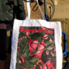 Bower of Bliss tote bag designed by Linder, hanging from the handle of a mobility device