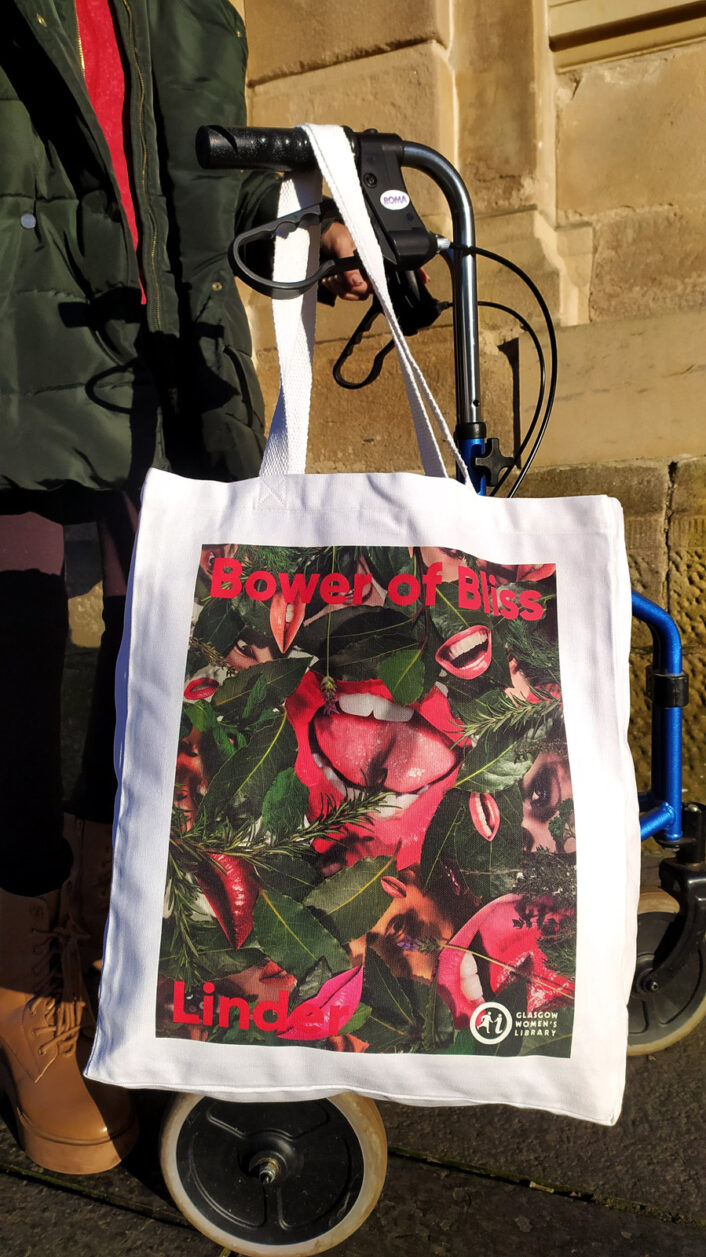 Bower of Bliss tote bag designed by Linder, hanging from the handle of a mobility device