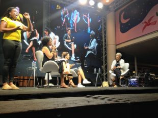 Patricia Hill Collins Interviewed by Ana Maria Gonçalves - they're sitting on a stage with video of the interview projected on a stage behind them, and a sign language interpreter in the foreground