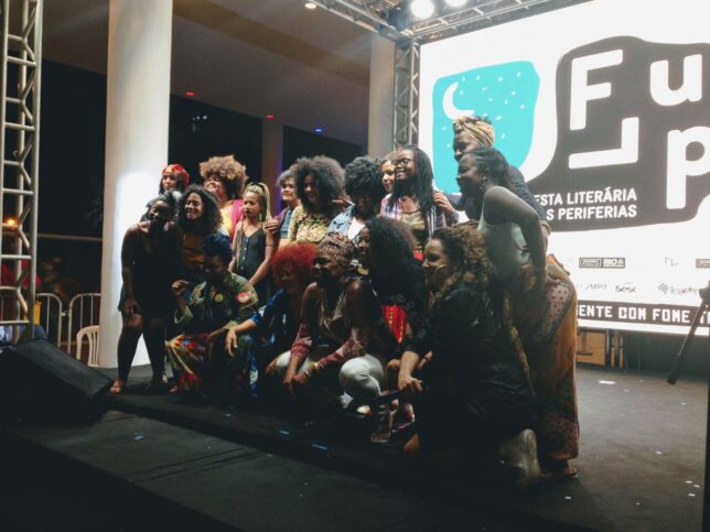 Flup 2019 Slam poets - a group of black women photographed in front of the Flup festival logo