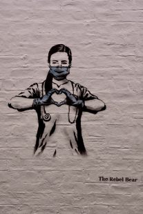 Mural depicting a doctor or nurse wearing a face mask and holding her hands together to make the shape of a heart