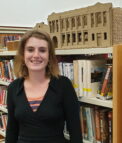 Mattie in front of a bookshelf