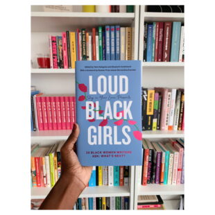 a hand holds a book up in front of a bookcase filled with books. The book is "LOUD BLACK GIRLS" which is written in white text (bold and uppercase) across the blue and pink cover. 