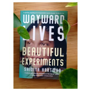 the book cover for "Wayward Lives Beautiful Experiments" sits on a table