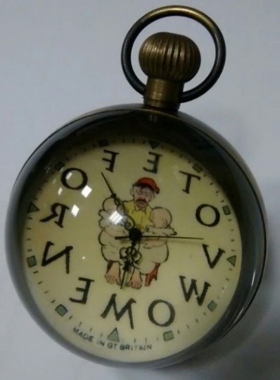 a pocket watch where the numbers are replaced by letters which read, clockwise, "V O T E S F O R W O M E N"