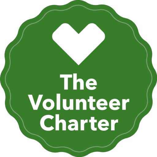 The Volunteer Charter logo. A green badge with the words "the volunteer charter" in white.