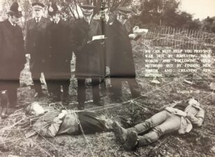 Two women lying down covered in string, forming a web and attached to nearby fences. Standing over them are six policemen, two writing notes. There is a quote from Virginia Woolf which reads: ‘We can best help you prevent war not by repeating your words and following your methods but by finding new words and creating new methods’ 