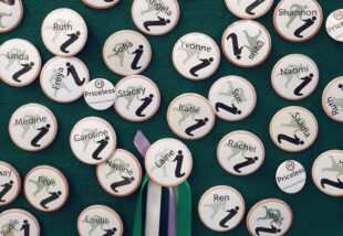 Glasgow Women's Library name badges on a green felt background. Names include Katie, Sue, Yvonne, Freya, Ren and Naomi amongst others.