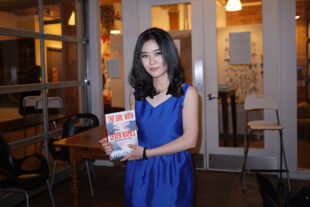 Lee Hyeon-seo in a blue dress holding her book.