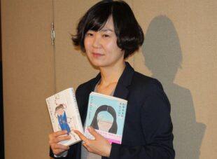 Photo of Cho Nam-joo holding two editions of her book.