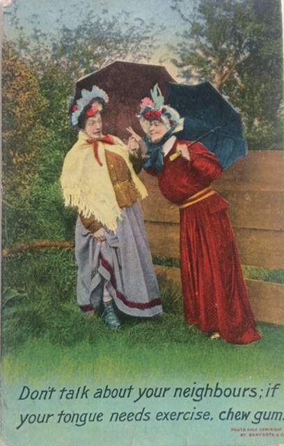 Colourised photograph postcard with two women chatting beneath parasols, with the title 'Don't talk about your neighbours; if your tongue needs exercise, chew gum.'