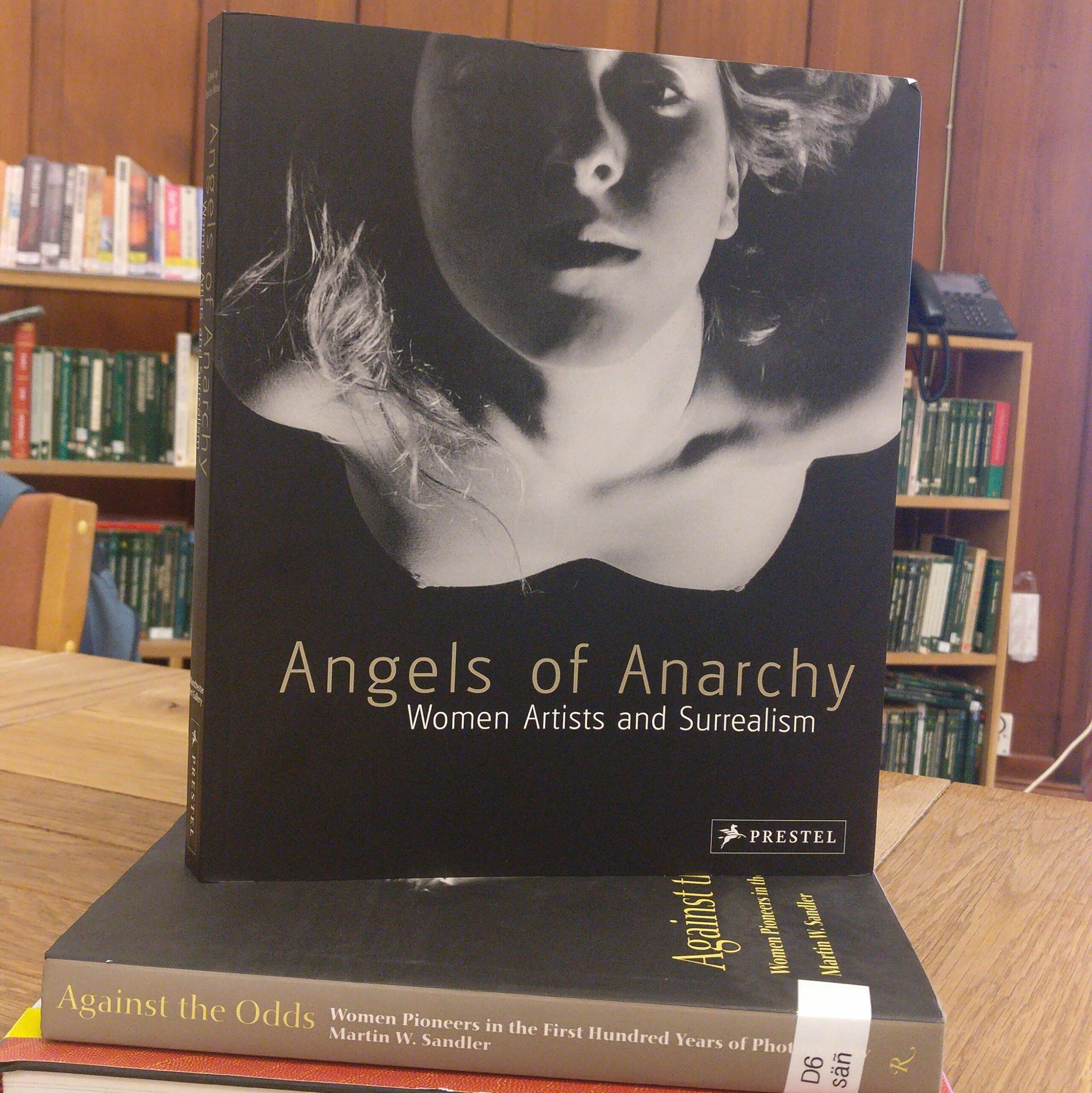 Depicting the front cover of 'Angels of Anarchy', a black and white image of a woman looking up at the camera, the title of the book below her. 