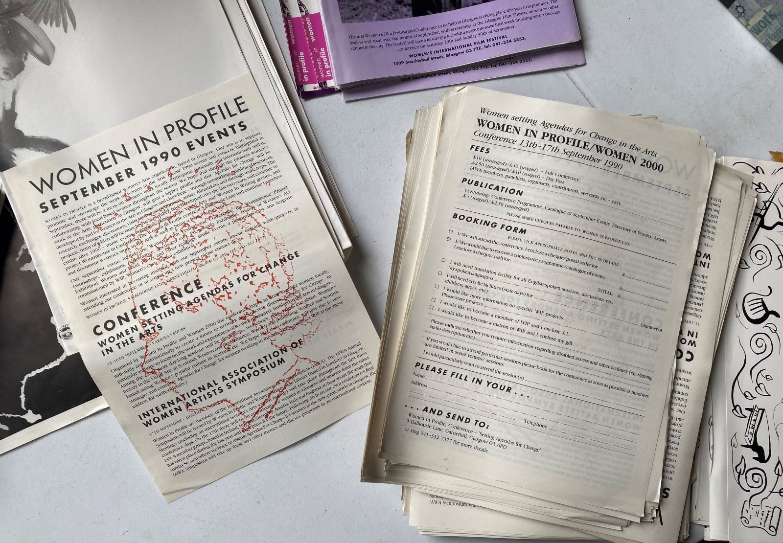 Archive material displayed on a table titled the Women in Profile September 1990 events alongside conference RSVPs and the Women in Profile film festival programme.