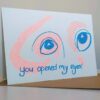 Two wide blue eyes look out. There is orange shading around the eyes. "You opened my eyes" is handwritten in blue.