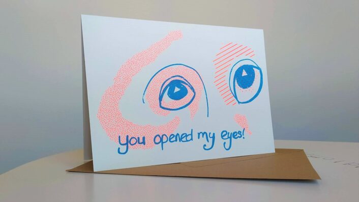 Two wide blue eyes look out. There is orange shading around the eyes. "You opened my eyes" is handwritten in blue.