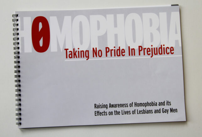 A photo of a printed, ringbound document. Cover reads 'Homophobia: Taking no pride in prejudice. Raising awareness of homophobia and its effects on the lives of lesbians and gay men'