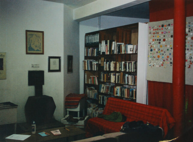 A photograph showing shelves of archival materials. On the right is a board displaying badges from the collection.