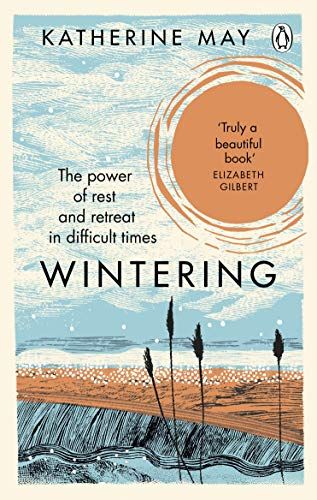 The book cover for Wintering by Katherine May, which includes a beautiful illustration of a winter scene, with a orange moon and snowy sky