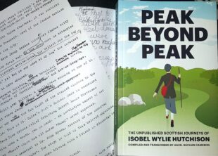 Some type writer typed notes sit beside a book titled Peak Beyond Peak. The cover of the book shows an illustration of a woman walking surrounded by greenery