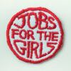 Circular logo patch with 'Jobs for the girls' in red capitals on white
