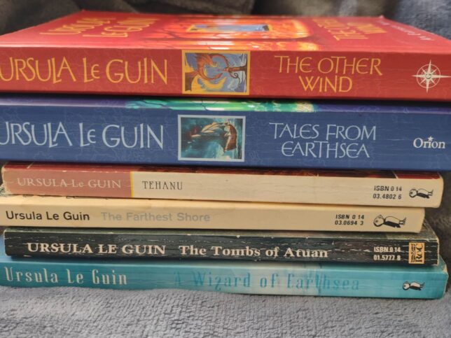 The Earthsea Cycle (6 different books) by Ursula Le Guin, stacked on top of each other.