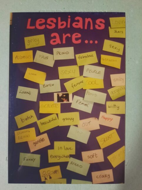 Photo of a large board with the title "lesbians are..." at the top. Below are lots of post-it notes with different words including: loving, butch, beautiful and proud