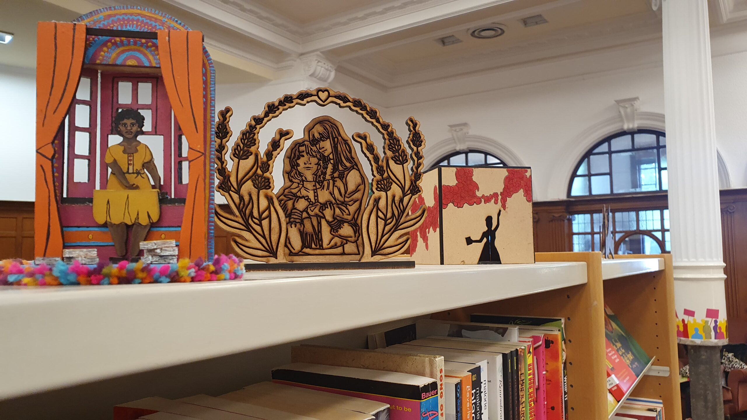 Elaborate 3D cutout illustrations on shelvs in the GWL main library space