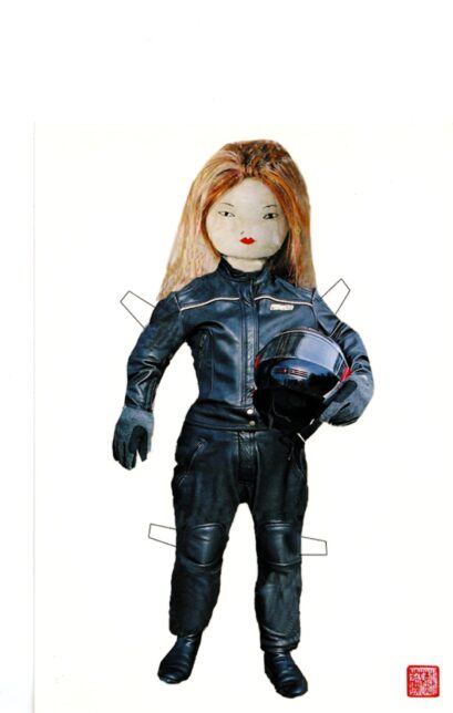 Postcard shows soft toy Chinese doll dressed in black motorcycle leather with helmet in hand.